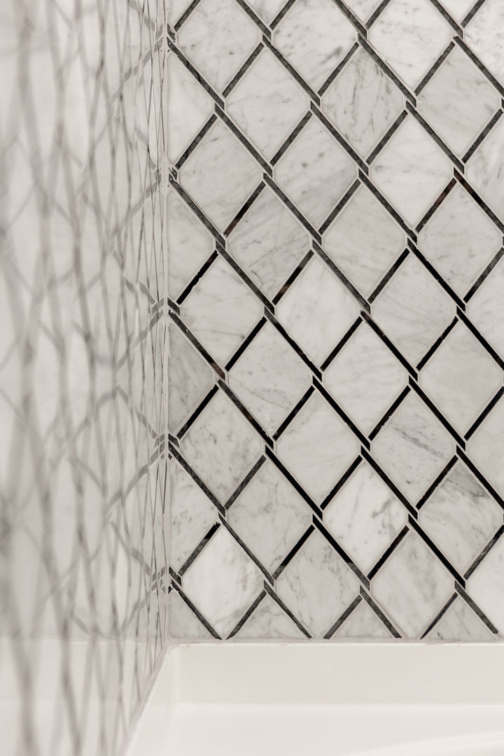 Displayed in a real-world installation, the Lavaliere Carrara White and black antique mirror chain link polished mosaic introduces bold pattern and shine