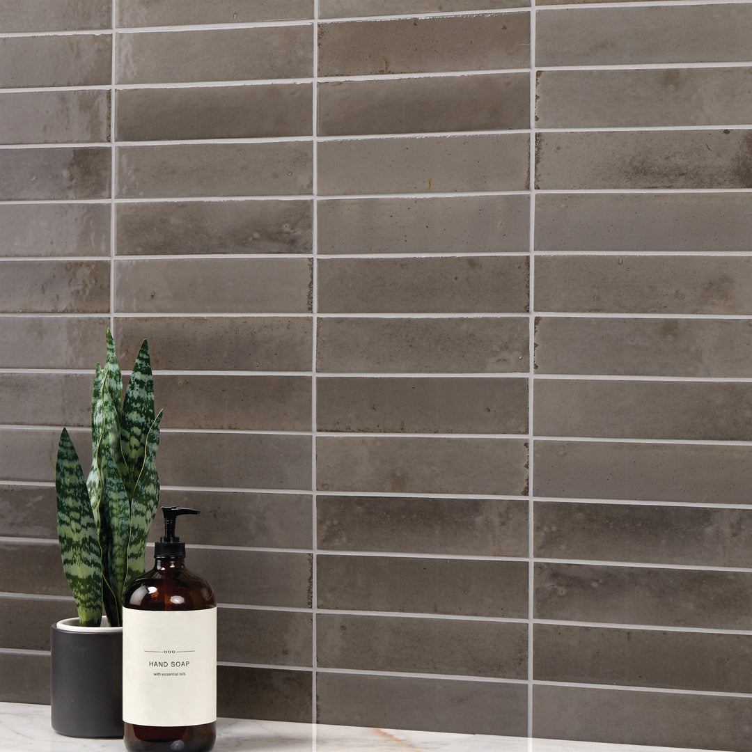 Remedy Zen 2x10 glossy glazed porcelain tile features sleek lines and a reflective finish for a spa-inspired surface design.
