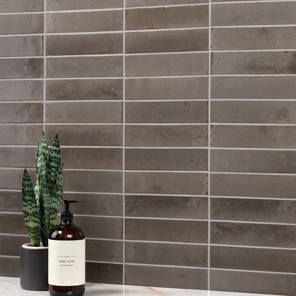 Remedy Zen 2x10 glossy glazed porcelain tile features sleek lines and a reflective finish for a spa-inspired surface design.