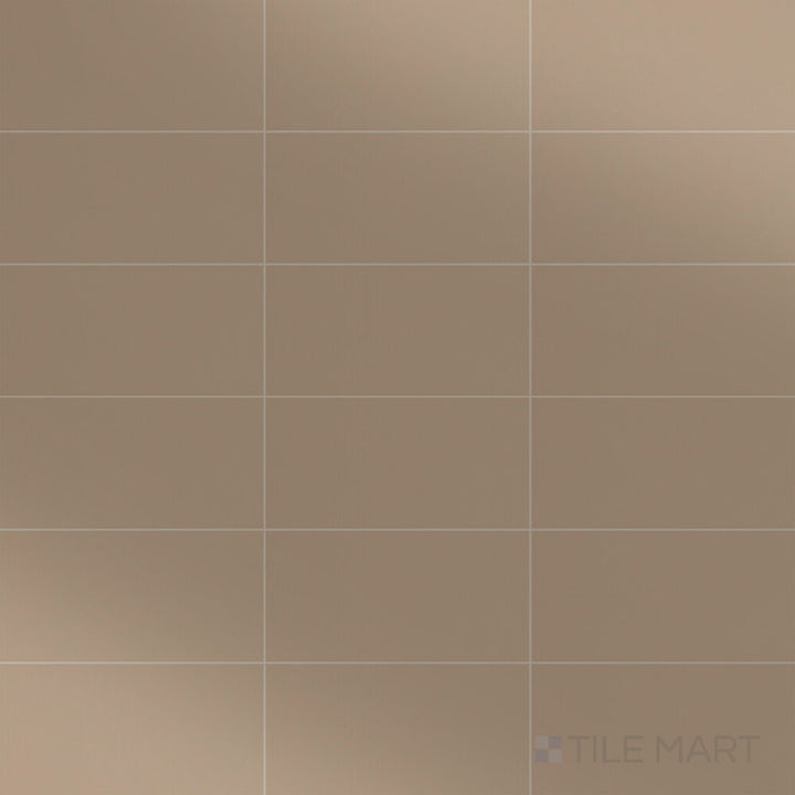 A top-down view of the Color Wheel Classic Elemental Tan 3x6 glossy glazed ceramic tile showcases a warm, earthy tan hue with a reflective finish, adding natural elegance to any space.