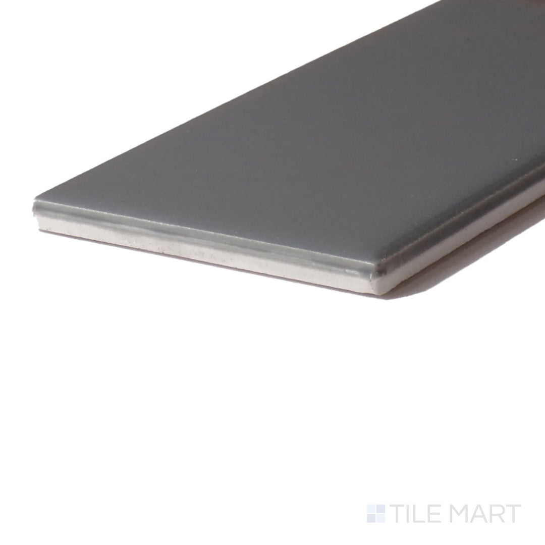 Side perspective of Color Wheel Classic Suede Gray 3X6 Glossy Glazed Ceramic, capturing its sophisticated gray shade with a polished, reflective surface.