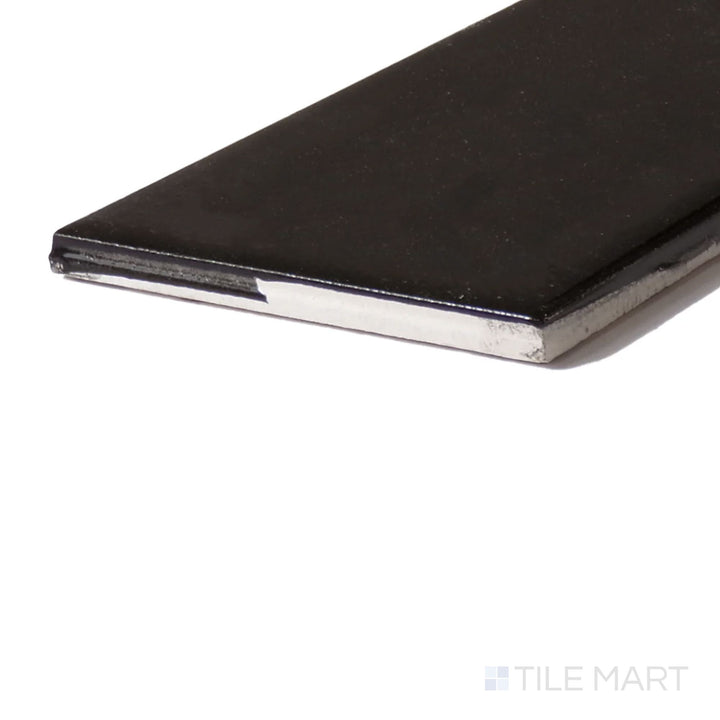 Corner-focused shot of Color Wheel Classic Black 3X6 Glossy Glazed Ceramic, highlighting its deep, bold black shade with a stunning reflective gloss.