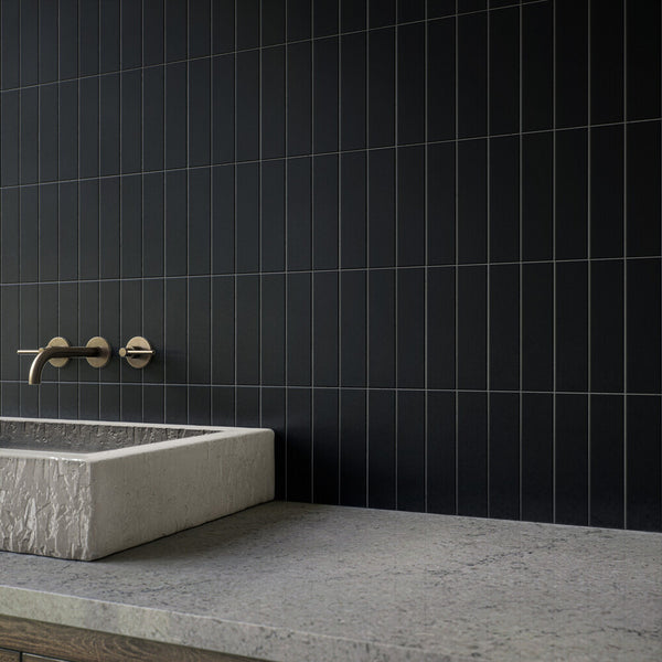 Matte meets minimalism in this roomscene featuring Color Wheel Linear Black 2x8 matte glazed ceramic tile, offering a contemporary take with bold edges and soft texture.