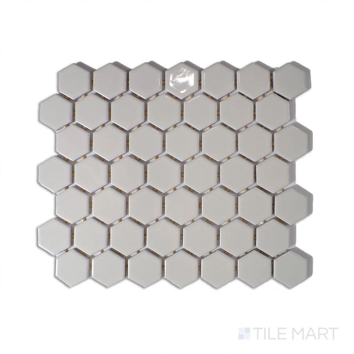 Diagonal view of Color Wheel Mosaic Biscuit 1.5" hexagon glossy glazed ceramic tile, featuring a warm beige tone with a polished finish in a contemporary hexagonal layout.  