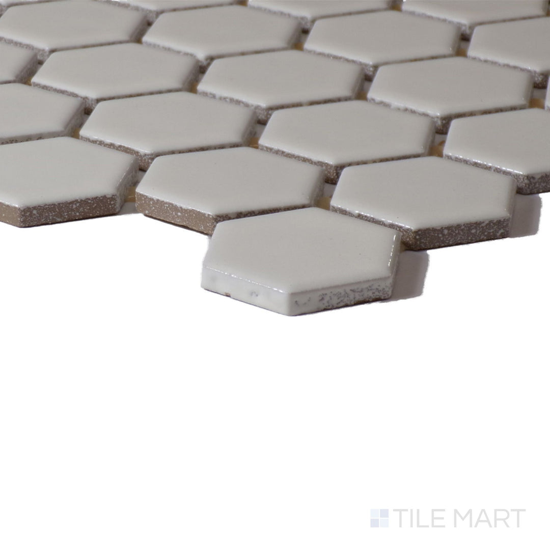 Angled shot of Color Wheel Mosaic Biscuit 1.5" Hexagon Glossy Glazed Ceramic, displaying its soft beige shade with a glossy sheen that enhances light.