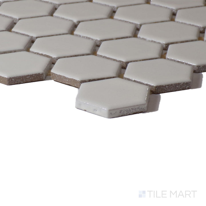 Angled shot of Color Wheel Mosaic Biscuit 1.5" Hexagon Glossy Glazed Ceramic, displaying its soft beige shade with a glossy sheen that enhances light.