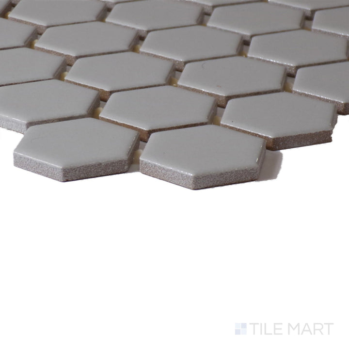 Close-up corner perspective of Color Wheel Mosaic Desert Gray 1.5" Hexagon Glossy Glazed Ceramic, showcasing its modern gray hue with a reflective glaze.
