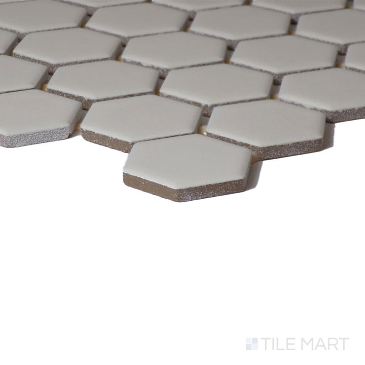 Angled close-up of Color Wheel Mosaic Biscuit 1.5" Hexagon Matte Glazed Ceramic, featuring its soft beige color and understated matte glaze.