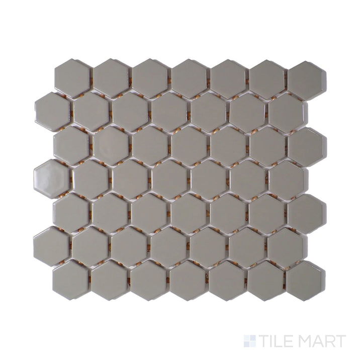 Angled shot of Color Wheel Mosaic Architectural Gray 1.5" hexagon glossy glazed ceramic tile, showcasing a soft gray tone with a glossy finish in a modern hexagonal arrangement.  