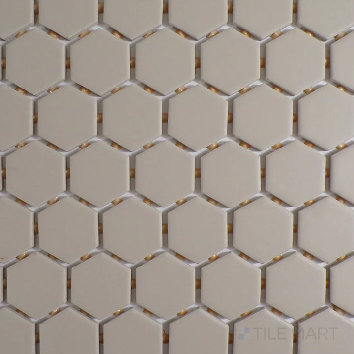 Viewed from the top, the Color Wheel Mosaic Urban Putty 1.5" hexagon glossy glazed ceramic tile presents a warm, neutral beige shade with a lustrous surface, ideal for sophisticated interiors.