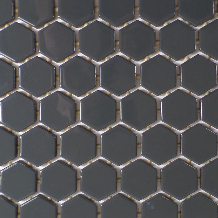 A top-down view of the Color Wheel Mosaic Chalkboard 1.5" hexagon glossy glazed ceramic tile reveals a bold, deep black hue with a reflective glaze, creating a dramatic and modern appeal.