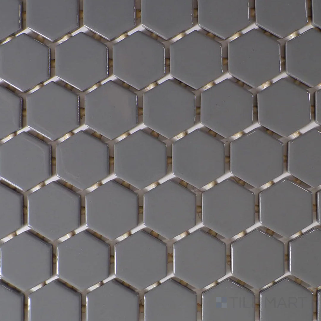 Captured from above, the Color Wheel Mosaic Suede Gray 1.5" hexagon glossy glazed ceramic tile displays a subtle gray shade with a polished finish, enhancing contemporary and minimalist spaces.