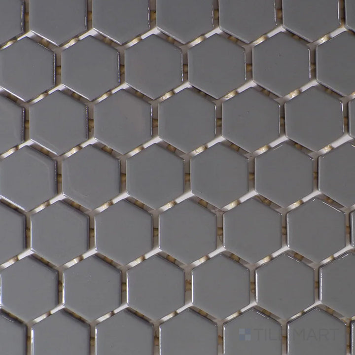 Captured from above, the Color Wheel Mosaic Suede Gray 1.5" hexagon glossy glazed ceramic tile displays a subtle gray shade with a polished finish, enhancing contemporary and minimalist spaces.
