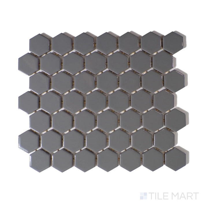 Angled shot of Color Wheel Mosaic Suede Gray 1.5" hexagon glossy glazed ceramic tile, showcasing a muted gray tone with a polished texture in a geometric hexagonal layout.  