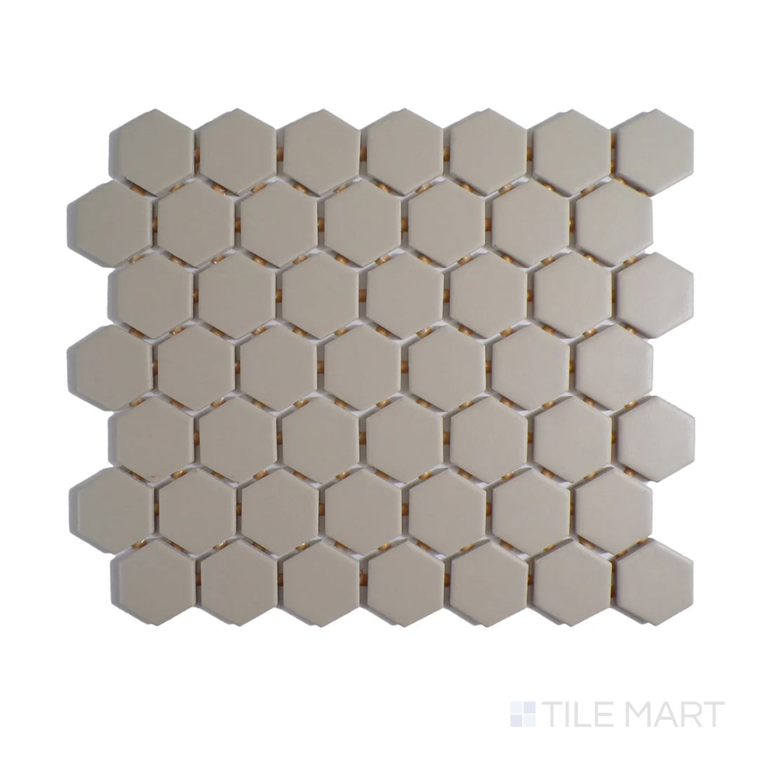 Diagonal view of Color Wheel Mosaic Urban Putty 1.5" hexagon matte glazed ceramic tile, featuring a neutral putty shade with a smooth, non-glossy finish in a structured hexagonal layout.  