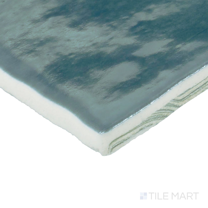 Corner view of Zellige Neo Petrolio 4x4 glossy glazed ceramic tile revealing deep color shifts and artisanal glaze detail.