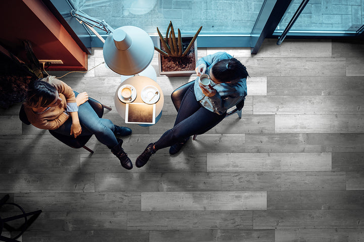 A sophisticated and modern space featuring Andover Kingsdown Gray 7X48 Low Gloss Luxury Plank Vinyl, with refined gray tones and realistic wood textures.