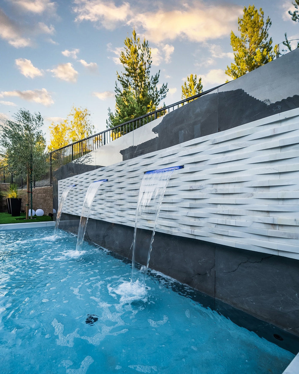 Displaying the refined texture of COSMIC WHITE 3D WAVE 6X24 PANEL MARBLE PANEL with a HONED finish, blending effortlessly with the surrounding modern elements.