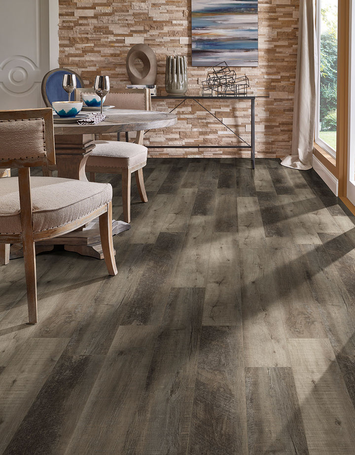 A bold and elegant wood-look plank, Cyrus Wolfeboro 9X60 Low Gloss Luxury Plank Vinyl blends deep brown and gray tones with authentic wood grain textures.
