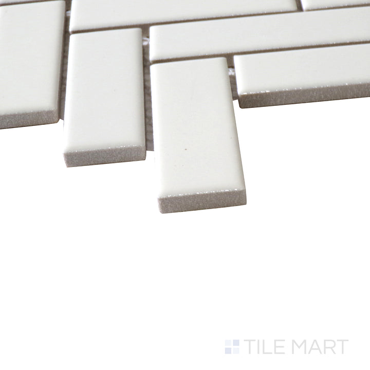 Corner shot of ALMOND GLOSSY HERRINGBONE MOSAIC PORCELAIN MOSAIC with a GLOSSY finish, highlighting the precision of the product's edge and the substantial thickness.