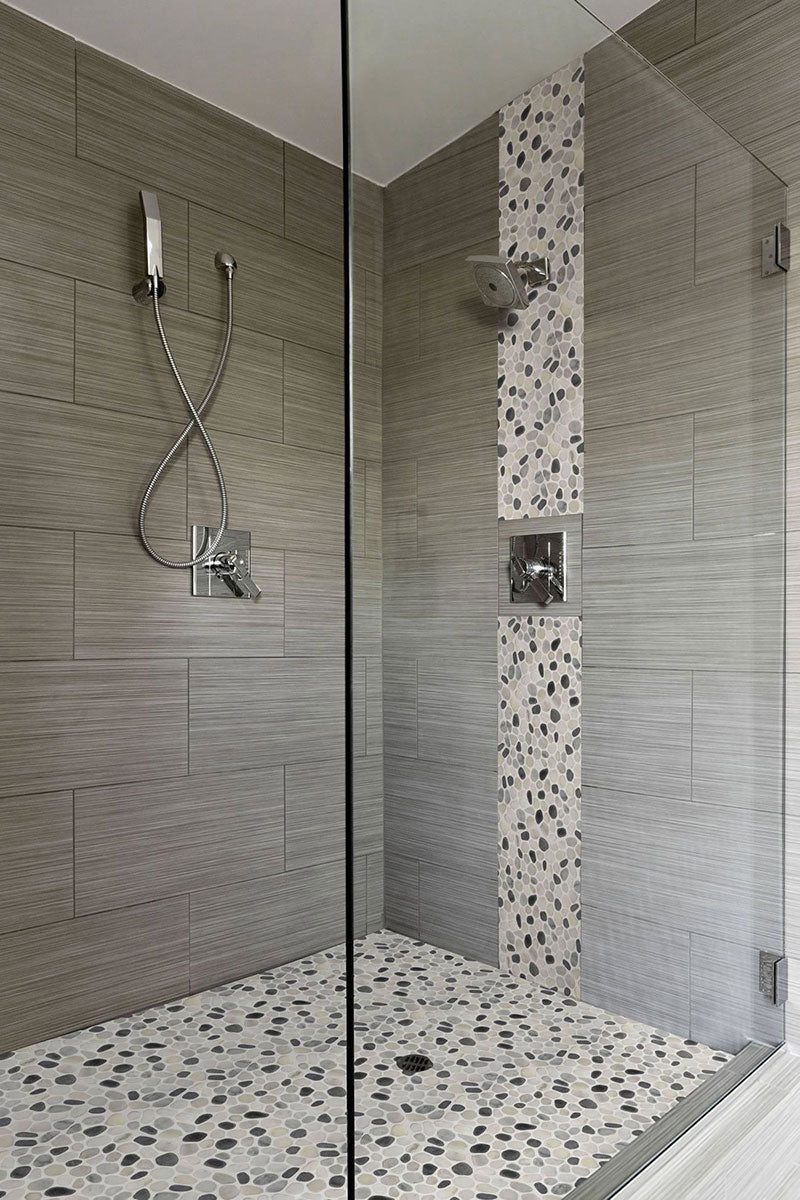 Displaying the refined texture of BLACK AND WHITE PEBBLES MESH BACKED PORCELAIN MOSAIC with a TUMBLED finish, providing a durable yet stylish look to the interior.