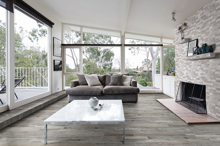 Eclectically designed space with Prescott Mezcla 7x48 vinyl flooring, combining varied wood tones in wide planks to enhance the layered, artistic energy of the room.