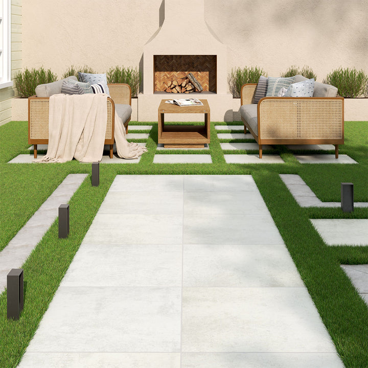 A sleek and modern outdoor space featuring Benton Blanco 24x24 matte porcelain pavers. The bright white surface enhances the open-air ambiance, creating a fresh and sophisticated patio or terrace setting.