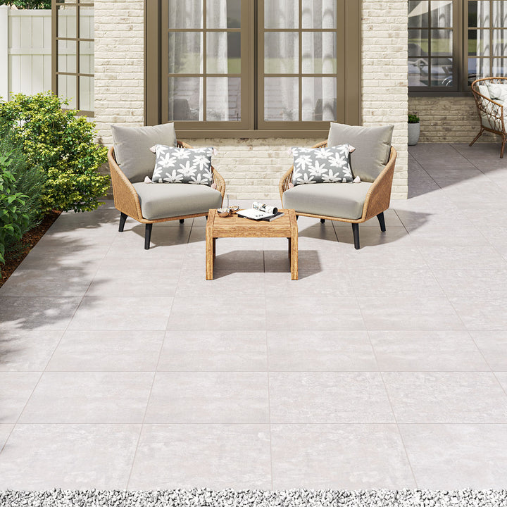 A contemporary outdoor lounge area with Benton Grey 24x24 matte porcelain pavers. The subtle grey tones blend seamlessly with modern landscaping, offering a stylish and durable foundation for any exterior space.