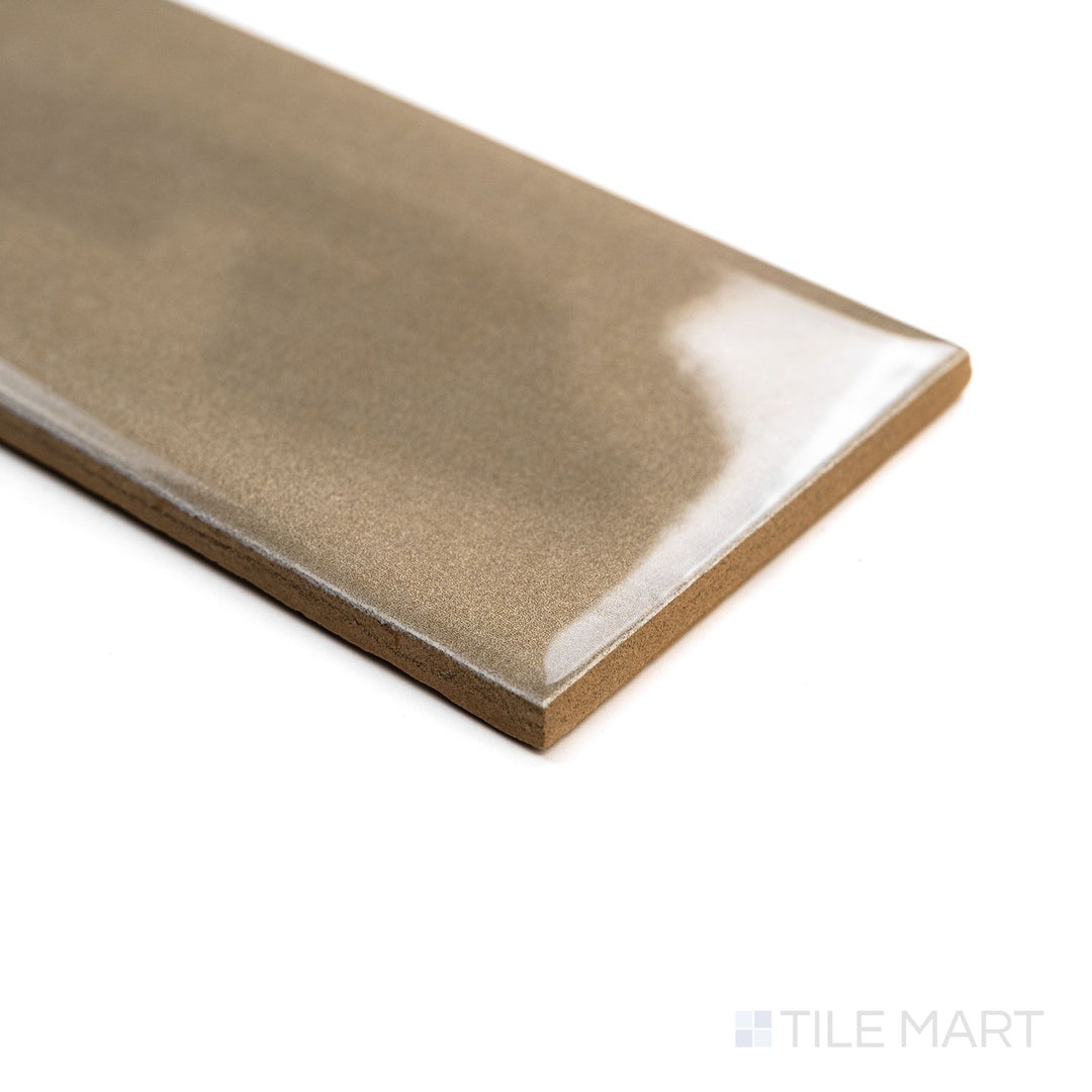 Angled image of Canvas Desert Sand 3x10 Glossy Ceramic Tile capturing its warm beige color and reflective surface with soft edge lighting.
