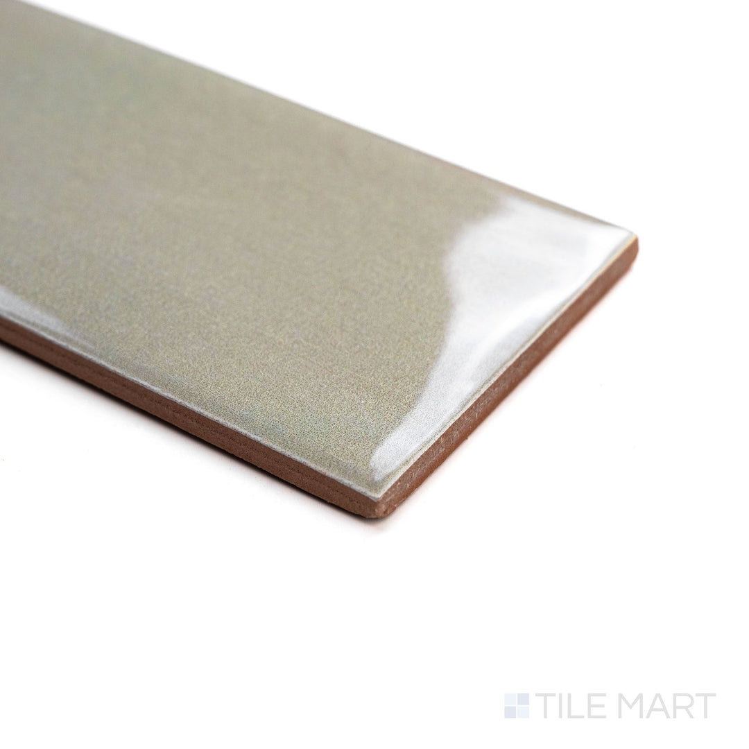 Canvas Moon Gray 3x10 Glossy Ceramic Tile shown from a corner view, emphasizing its neutral gray shade and high-gloss shine with dimensional contrast.