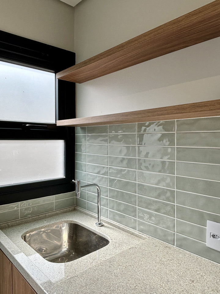 Canvas Quiet Sage 3x10 Glossy Ceramic Tile placed in a calming interior, offering a gentle green tone and a sleek surface that enhances the room’s ambiance.