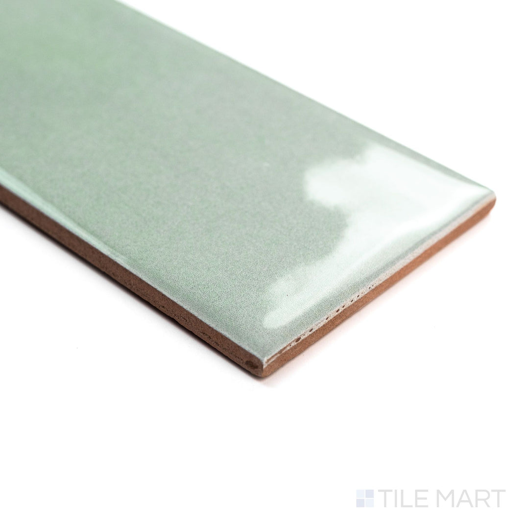 Corner angle shot of Canvas Quiet Sage 3x10 Glossy Ceramic Tile with a muted green glaze and glossy finish that enhances its refined appearance.