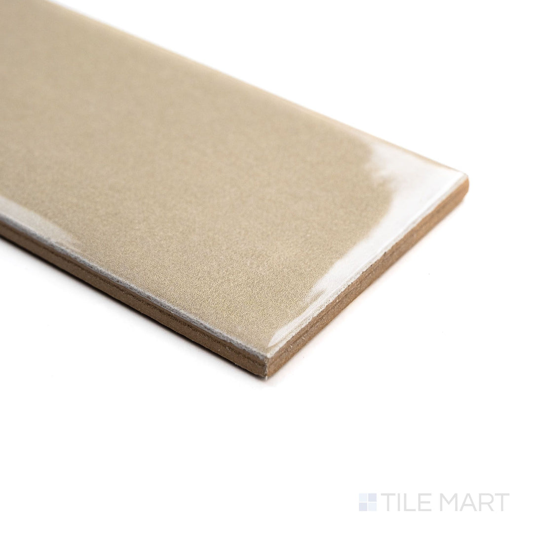 Angled shot of Canvas Sago Pearl 3x10 Glossy Ceramic Tile showcasing its creamy off-white tone and lustrous surface with natural light reflections.