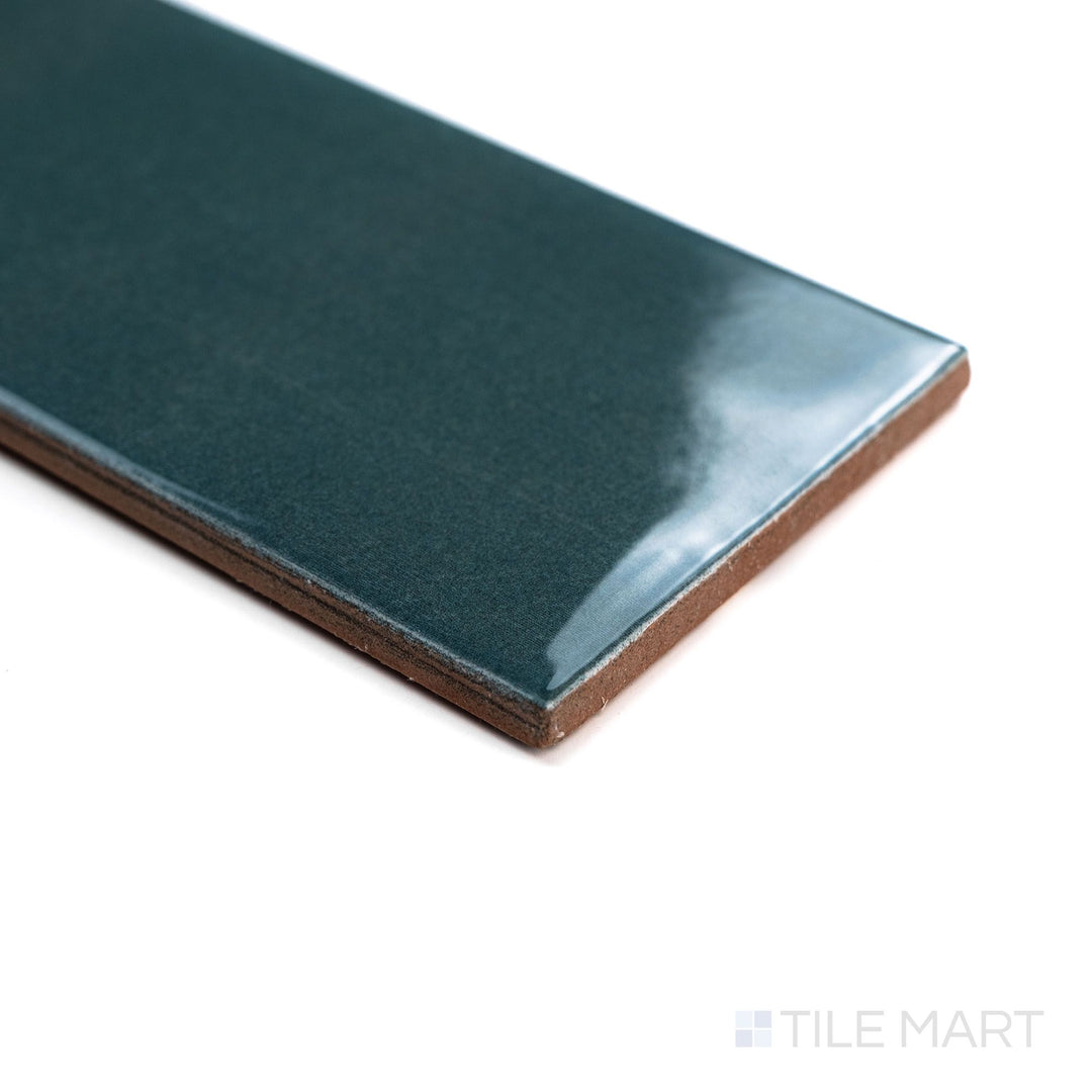 Canvas Midnight Jade 3x10 Glossy Ceramic Tile photographed at an angle, emphasizing its deep green tone and sleek finish with corner shadows.