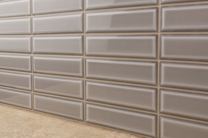 A stylish interior featuring Boutique Sleek Fossil 3x9 beveled glossy ceramic tiles, adding a refined touch with their neutral hue and sleek reflective surface.