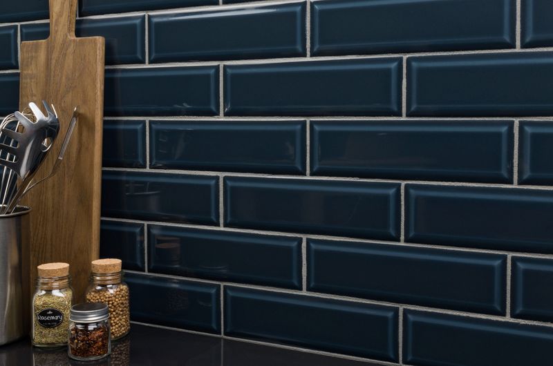 A contemporary setting with Boutique Sleek Indigo 3x9 beveled glossy ceramic tiles, showcasing their deep blue hue and elegant shine in a real-life design.