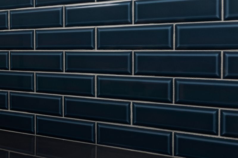 A modern space with Boutique Sleek Indigo 3x9 beveled glossy ceramic tiles, showcasing their deep blue tone and polished finish for a bold statement.