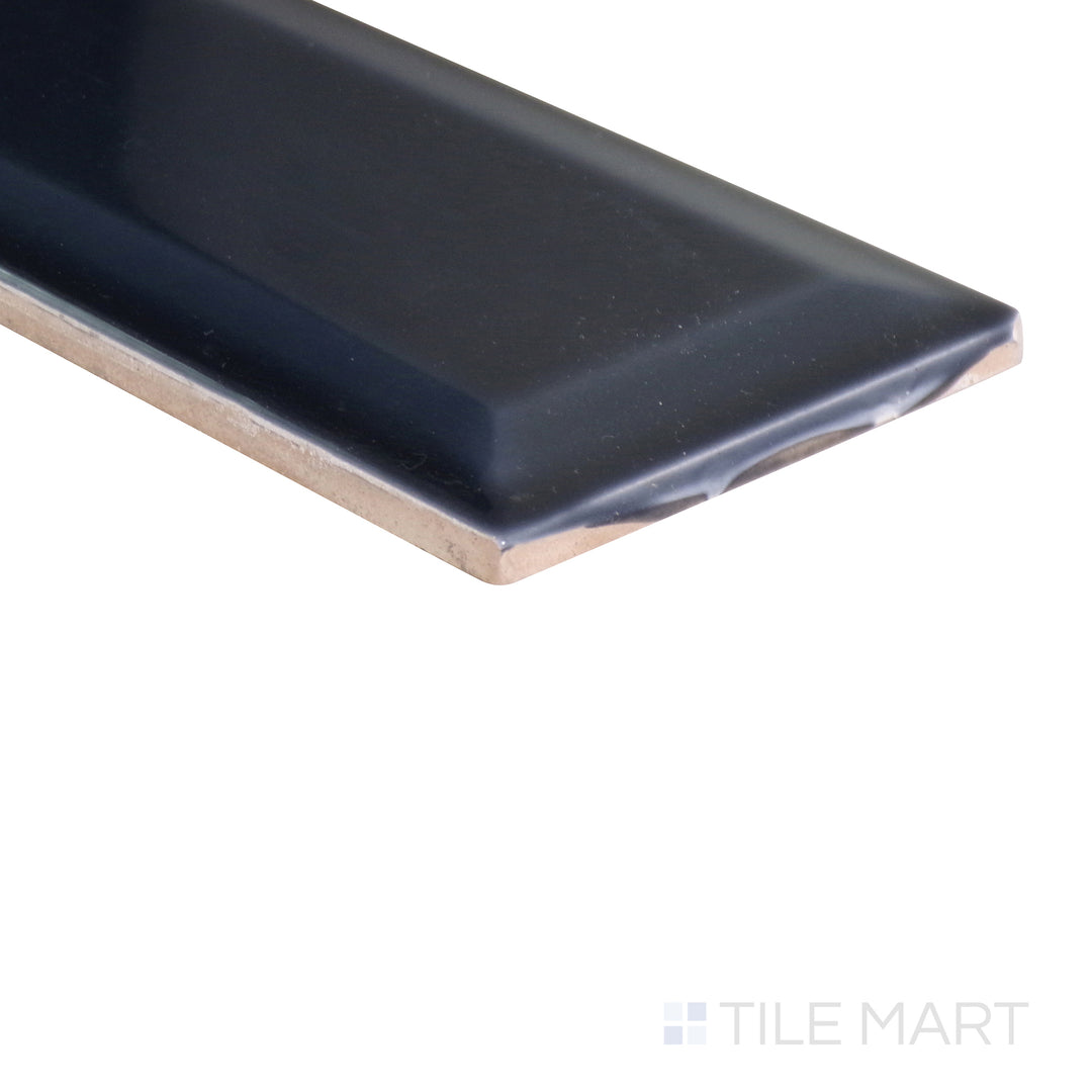 An angled view of the indigo blue tile from the Boutique Sleek series, emphasizing its glossy finish and bold color.