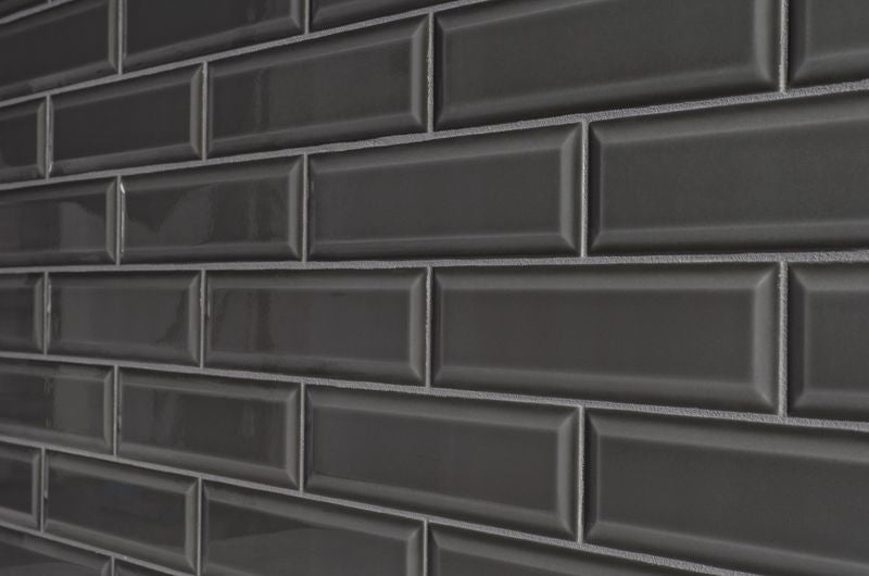 A sophisticated room scene with Boutique Sleek Sable 3x9 beveled glossy ceramic tiles, enhancing the space with a rich dark shade and a high-gloss sheen.