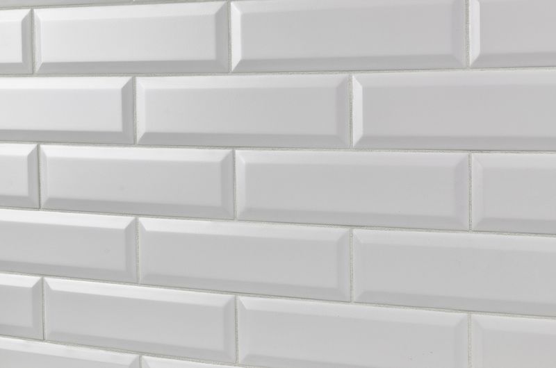 A minimalist interior featuring Boutique Sleek Salt 3x9 beveled matte ceramic tiles, providing a soft, refined look with a subtle textured surface.