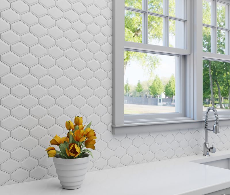 A contemporary setting with Foundations Plaster Structure Elongated Hex glossy ceramic mosaic, emphasizing its unique geometric pattern and sleek glaze.