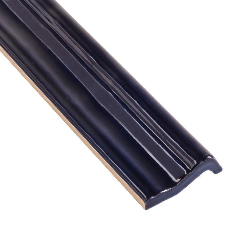 A close-up corner shot of Moroccan Habitat Peacock 2x12 glossy ceramic chair rail, featuring its bold color and smooth, curved profile.