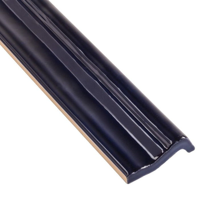 A close-up corner shot of Moroccan Habitat Peacock 2x12 glossy ceramic chair rail, featuring its bold color and smooth, curved profile.