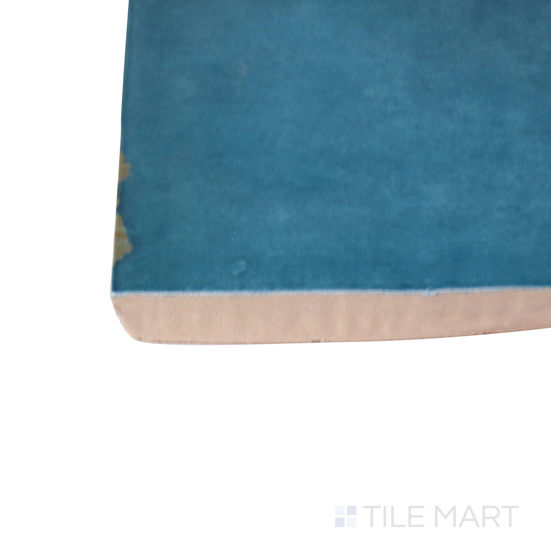 A detailed corner view of the indigo blue tile, revealing its solid construction and substantial thickness.