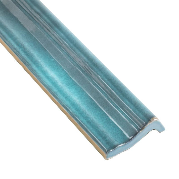 A detailed corner shot of Moroccan Habitat Seaside 2x12 glossy ceramic chair rail, highlighting its smooth curves and ocean-inspired color.