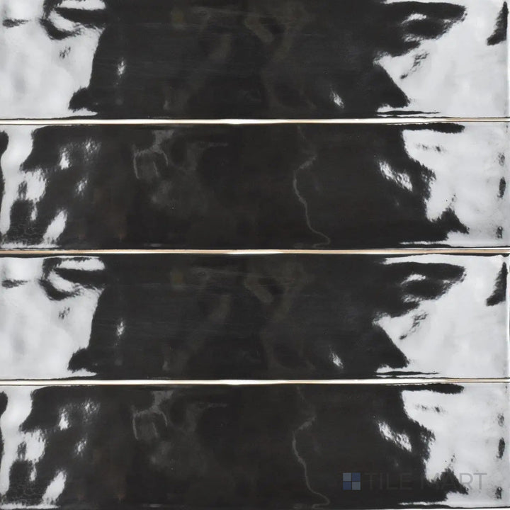 An overhead angle highlights the glossy sheen of the Artesano Black 3x12 inch bright ceramic tile, emphasizing its rich black color and reflective surface for a bold, contemporary look.