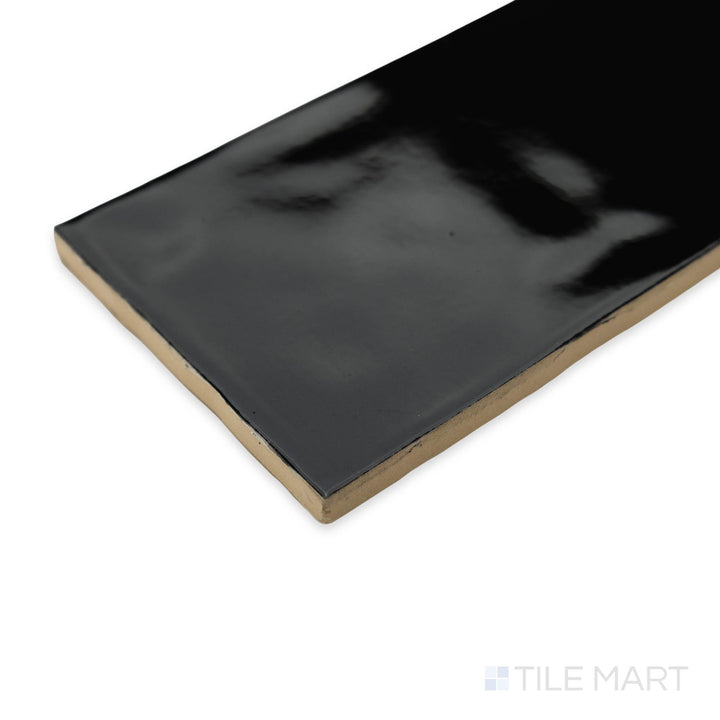 Corner view of Artesano Black 3X12 bright ceramic tile, showcasing its deep black tone, glossy surface, and sharp tile edges meeting at a crisp angle.