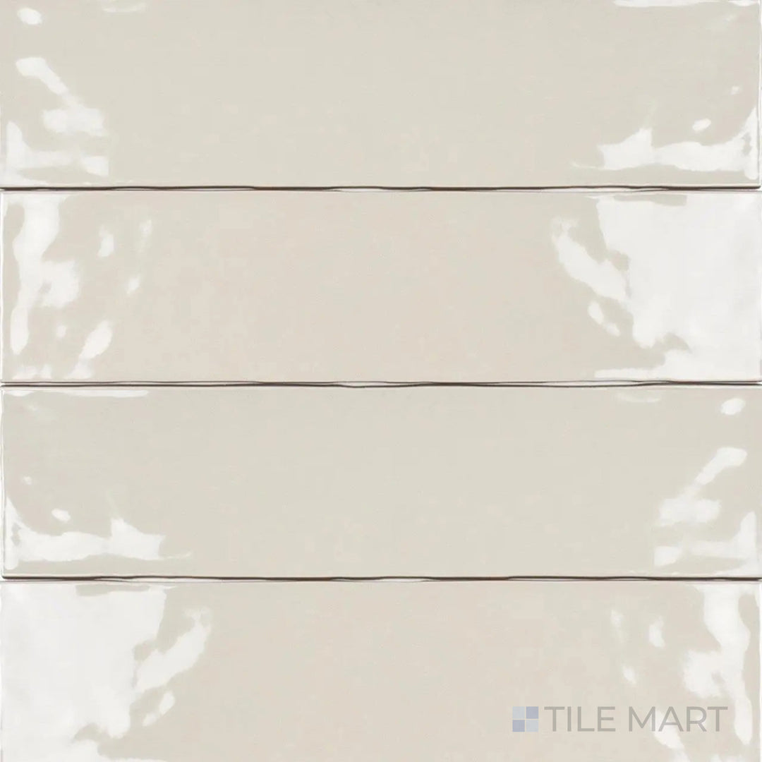 From a high-angle view, the Artesano Biscuit 3x12 inch bright ceramic tile showcases a warm beige hue with a glossy surface, adding subtle sophistication to any space.