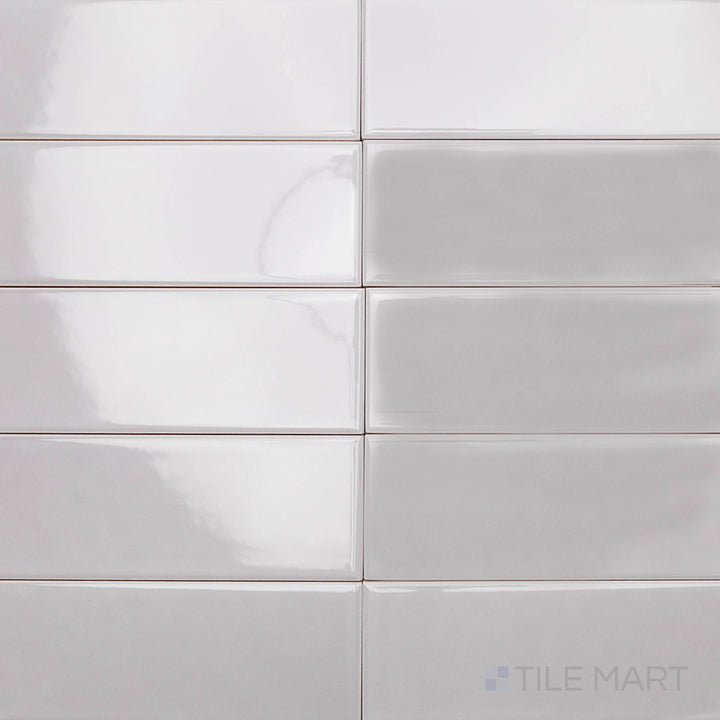 A sleek, steel-gray ceramic tile with a glossy finish, viewed from above to highlight its smooth texture and elongated 2x10 inch shape, ideal for contemporary spaces.
