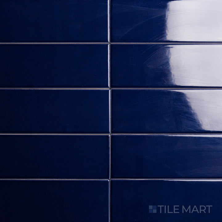 With a deep blue color and a glossy finish, the Block Azul 2x10 inch bright ceramic tile is shown from above, emphasizing its bold, sophisticated look.